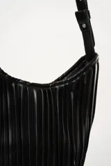 Cartera tipo hobo color crema con diseño plisado y correa de hombro ajustable.