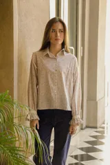 Camisa de algodón con estampado floral, cuello clásico, cierre frontal con botones, mangas largas con puños con volados y corte recto.