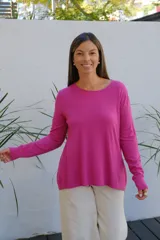 Sweater de punto color magenta, con cuello redondo, manga larga con puños acanalados y corte holgado.