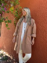 Tapado desestructurado de lana y viscosa, de corte oversize y diseño liviano. Presenta solapas clásicas, mangas largas con puños vueltos y dos bolsillos frontales de parche.