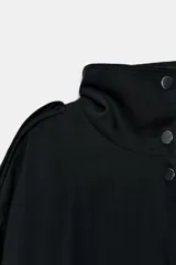 Chaqueta oversize de modal con cuello subido, cierre frontal con botones a presión y mangas largas con puños elásticos. Presenta trabillas en los hombros, bolsillos de vivo en el delantero y bajo abullonado con elástico.