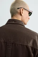 Camisa de corte relajado confeccionada en pana de algodón, con cuello solapa, manga larga con puños abotonados y cierre frontal de botones.