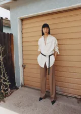 Pantalon de vestir color tostado con diseño wide leg, tiro alto y detalle de pinzas frontales. Cuenta con bolsillos laterales y cierre oculto con botón, gancho y cremallera.