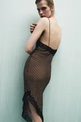 Vestido corto asimétrico con estampado geométrico en tonos marrones y naranjas. Presenta escote en pico, tirantes finos y detalles de encaje negro en el escote y el bajo.