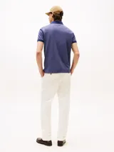 Chomba azul con tejido jacquard, cuello tipo chomba, cartera de dos botones y logo de Tommy Hilfiger bordado en la manga.