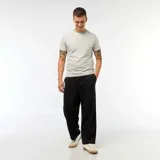 Pantalón de corte ancho y tiro medio, confeccionado en algodón de color negro, con diseño liso y bolsillos laterales.