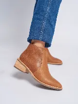 Botas cortas de cuero color marrón claro, con puntera fina y taco bajo de madera.