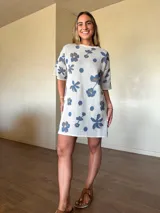 Vestido corto de tejido de punto de algodón con lurex, corte holgado, mangas cortas y cuello redondo, con diseño estampado floral y de lunares en tonos gris y lila sobre base beige claro.