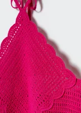 Top de crochet color fucsia, con diseño crop, cuello halter y cierre de lazo en el cuello.