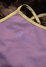 Top deportivo color lila con ribetes en amarillo claro. Presenta tirantes finos y un logo estampado en el centro en tono lila más oscuro.