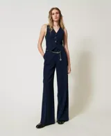 Pantalón de vestir azul marino con raya diplomática e hilo de lurex, corte palazzo, trabillas para cinturón, cierre con gancho y cremallera ocultos, pinzas delanteras, bolsillos diagonales en los laterales y bolsillos de ribete en la parte trasera, placa con el logo Oval T en la parte trasera.