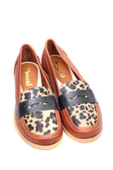 Mocasín plateado de cuero con detalle de vincha y suela plana color madera.