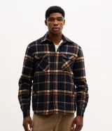 Campera trucker Marfinno para hombre de franela a cuadros en tonos azul marino, marrón y beige, con cuello inglés, cierre frontal de botones, bolsillos en el pecho con solapa, bolsillos laterales y forro interno de sherpa.
