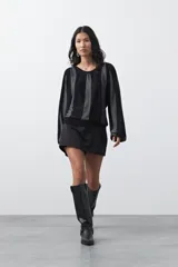 Short pollera de tiro medio con silueta recta y diseño tipo falda en el frente, confeccionado en tela de sastrería color marrón.