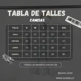 Camisa de vestir color beige claro, de cuello italiano y manga larga. Tiene un pequeño logo bordado en el pecho.