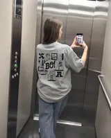 Remera gris de corte regular con estampa gráfica en la espalda que presenta un collage de estilo cómic con la palabra 'BO!' en el centro.