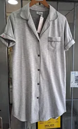 Camisón gris melange de algodón con solapas, mangas cortas y cierre frontal de botones. Cuenta con un bolsillo ojal en el pecho.