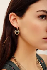 Aros colgantes dorados con dije en forma de corazón texturizado y centro negro.