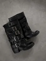 Botas altas negras de cuero sintético con múltiples tiras horizontales y hebillas metálicas plateadas. Cuentan con diseño fruncido y suela baja.