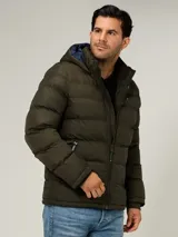 Campera puffer Tommy Hilfiger de color verde militar, con diseño acolchado horizontal, capucha integrada con interior azul y cierre frontal de cremallera. Cuenta con bolsillos laterales con cierre y el logo bordado en el pecho.