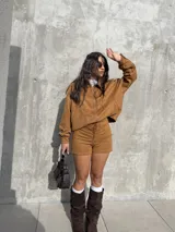 Campera de estilo bomber confeccionada en tejido tipo gamuza scuba, color marrón tostado. Presenta cierre frontal, cuello camisero, puños y ruedo elásticos, brindando un ajuste cómodo y versátil.