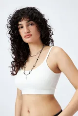 Top blanco sin costuras, de breteles finos y terminación acanalada.