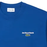 Remera de algodón color azul, de corte clásico y manga corta, con cuello redondo y logo de la marca bordado en el pecho junto a la frase 'Jeu Set et Match'.