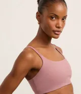 Top deportivo femenino color morado oscuro, de corte recto y ajustado, con escote cuadrado y breteles finos ajustables.