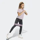 Remera deportiva Adidas de entrenamiento, color lila, con cuello redondo y mangas cortas. Presenta el logo de la marca en el pecho y las icónicas tres rayas blancas en los laterales. Diseñada con tecnología de absorción de sudor y ajuste clásico.