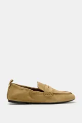 Mocasín de serraje color tostado, con copete subido, antifaz en la parte delantera y detalle fruncido en la parte trasera con tirador y aplique metálico.