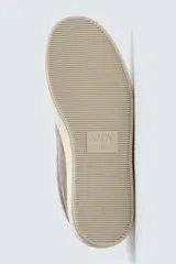 Zapatilla deportiva de hombre confeccionada en piel con acabado de serraje. Presenta un diseño minimalista con cordones al tono y un detalle en contraste de color en la pieza del talón. Cuenta con una suela de goma con volumen.