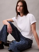 Remera Calvin Klein de algodón interlock color blanco, con cuello redondo, manga corta y emblema geométrico bordado en el pecho.