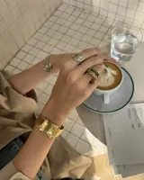 Brazalete rígido de diseño orgánico con textura irregular y acabado artesanal. Pieza abierta ajustable, disponible en bronce o alpaca maciza.