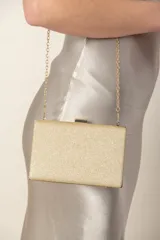 Cartera rectangular de lurex dorado con borde y cierre metálico plateado, y cadena fina dorada.