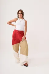 Pantalón de tiro alto con corte palazzo, color beige con bloques de color en marrón claro y blanco.