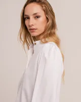 Blusa celeste de cuello mao y mangas abullonadas con puños elásticos. Tiene tajos laterales y botones en la delantera.