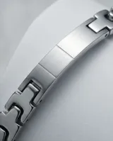 Pulsera de acero con eslabones gruesos y placa central rígida con detalle de circonia.