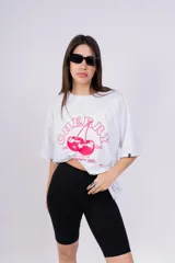 Remerón blanco de corte holgado con estampado de cerezas y texto en color rosa.