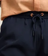 Bermuda de secado rápido color azul marino, con cintura elástica, cordón de ajuste y bolsillos laterales y traseros, ideal para uso casual o de playa.