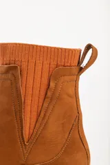 Bota tipo chelsea de caña media en color beige, con suela track dentada y paneles laterales elásticos acanalados.