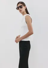 Camiseta sin mangas de color blanco, de diseño recto, con cuello redondo y hombreras, con corte peplum en la parte inferior.