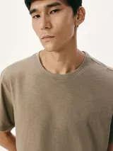 Camiseta básica de manga corta y cuello redondo, color marrón verdoso, con tejido texturizado.