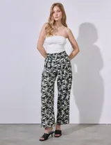 Pantalón largo de seda fría estampada con hojas en tonos verde, blanco y negro. Tiene pretina ancha elastizada.
