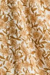 Blusa de viscosa con estampado floreado en tonos tostados y blancos, escote cuadrado, mangas largas abullonadas con puños elásticos y volados, y detalle fruncido bajo el busto.