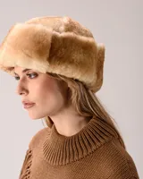 Gorro tipo ushanka de piel sintética en tono tostado, con diseño de solapas laterales y textura suave.
