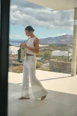 Pantalón de lino color blanco, de tiro alto y corte oxford con perneras amplias. Cuenta con cintura elastizada y bolsillos laterales.