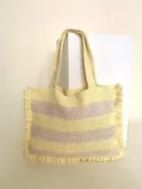 Bolso tipo tote tejido a crochet con hilo de algodón color marrón y crudo, con diseño a rayas horizontales y volados en los bordes.