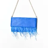 Bandolera azul con flecos en la parte inferior y cadena dorada.