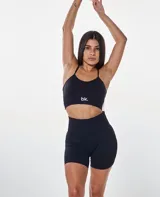 Conjunto deportivo de dos piezas color negro, compuesto por un top de tirantes finos con logo estampado y un short de tiro alto ajustado.