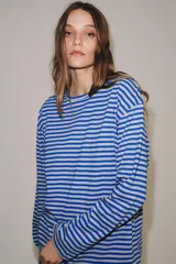 Remera de manga larga con diseño de rayas horizontales en tonos fucsia y rosado, cuello redondo y corte holgado.